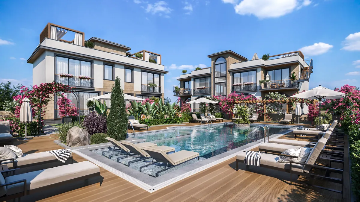 The Floral Homes swimming pool and timber sun deck, with two white and limestone apartment blocks behind and bougainvillea on the balconies